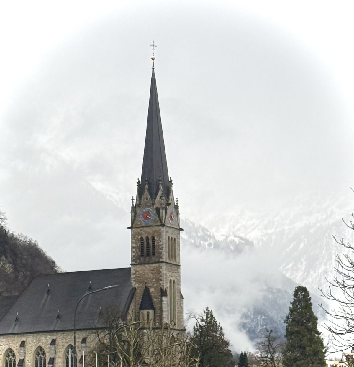 Church in Vaduz with snow-covered mountains behind it