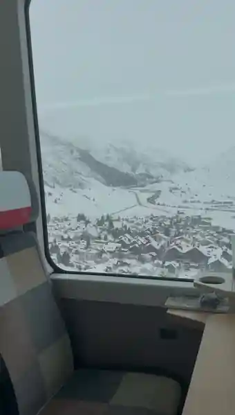 Snow-covered Swiss village seen through the Glacier Express window, photographed by Libby