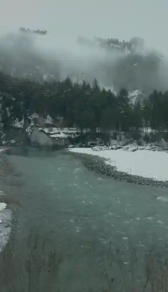 Turquoise river and snowy forest beside the Glacier Express route, photographed by Libby